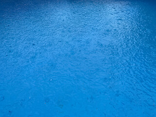 falling raindrops on the pool water surface