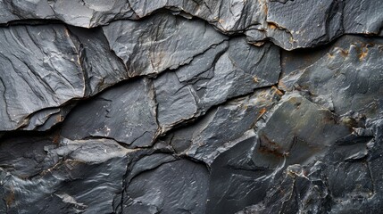 Detailed view of the rough, dark gray slate rock texture, showing intricate patterns and rugged surface