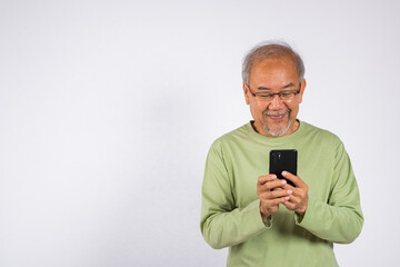 Portrait smiling Asian older man smiling holding a cell phone studio shot isolated on white background. elderly typing message on mobile phone in hand. Concept of connection and communication