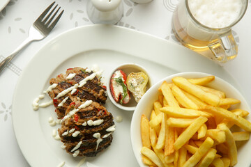 Tender mincemeat grilled with spices served with french fries and chilli peppers
