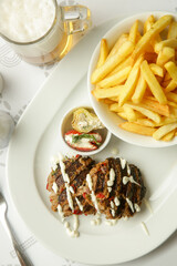 Tender mincemeat grilled with spices served with french fries and chilli peppers