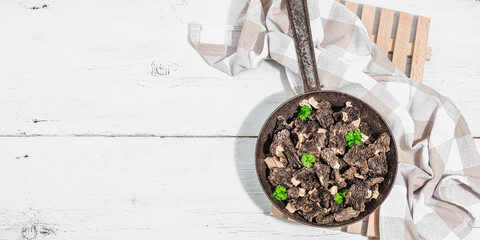 Raw black morel mushrooms with fresh parsley. Vegan ingredient for cooking healthy food