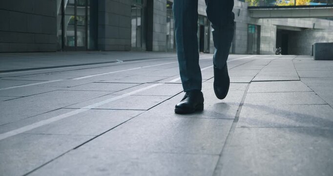 Close-up in legs strides confidently down empty urban street shoes symbol of assurance Radiates confidence echoing through city Confidence speaks of success cinematic slow motion shoot.