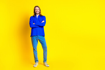 Photo of positive handsome man wear trendy blue pullover empty space isolated on yellow color background