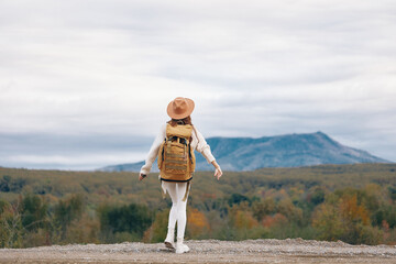 Mountain Woman: A Smiling Adventurous Traveler Taking a Selfie with her Phone amidst the Serene...