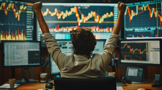 business man congratulations stock trader sitting at a desk in front of computer monitors