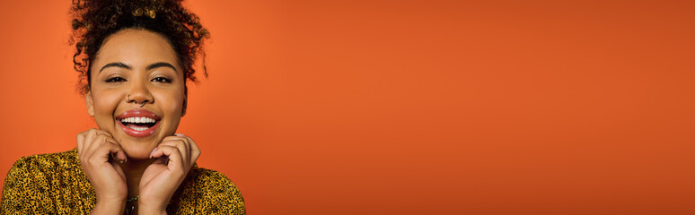 An African American woman in stylish attire, looking surprised.