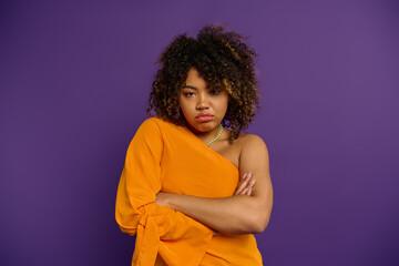 Confident African American woman posing with crossed arms in stylish attire.