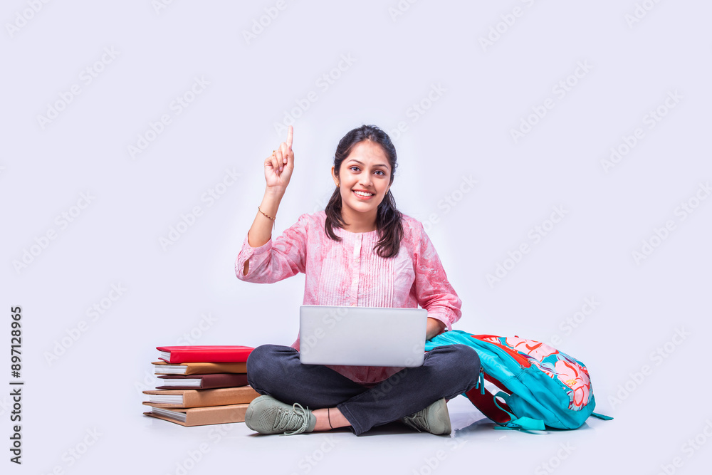 Wall mural indian asian pretty young female student studying sitting on white backgrounds