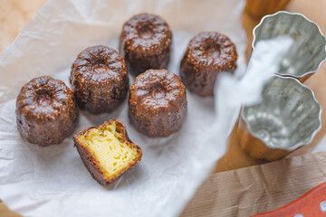 Caneles de bordeaux - traditional French sweet dessert with table background,Cannelés Recipe,small pastry rum and vanilla on a wooden plate,close up,french food,french cuisine,French Tourism,olympic