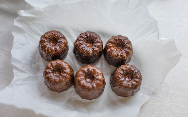 Caneles de bordeaux - traditional French sweet dessert with table background,Cannelés Recipe,small pastry rum and vanilla on a wooden plate,close up,french food,french cuisine,French Tourism,olympic