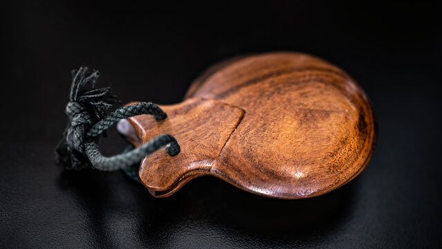 Wooden castanet for flamenco dance closeup on dark background. Traditional hispanic musical instrument for live perfomance