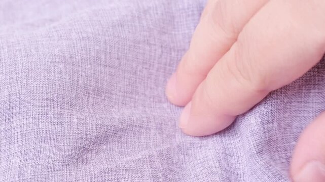 female Hand touching cotton, linen cloth, Seamstress tests texture, checking tactile and functional properties, sewing material, seamstress at work