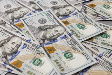 American hundred dollar paper money lies on the office table. Close-up of 100 American dollar bills. Currency exchange one hundred dollars. Investment, finance and income concept.