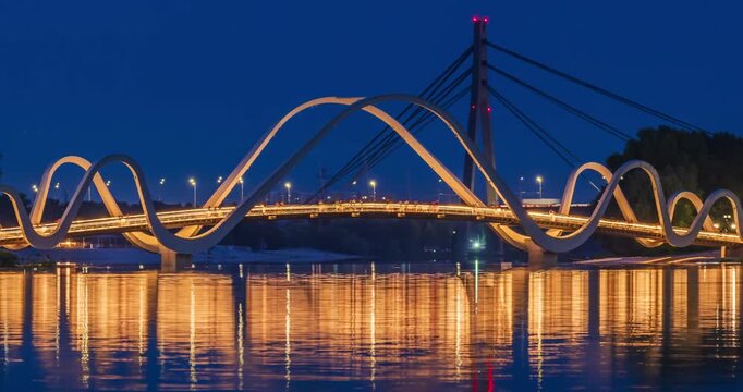 People move along an illuminated pedestrian bridge, Kyiv, Ukraine. Kiev, Ukraine. Time lapse.