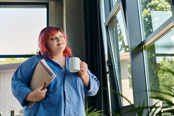A plus size woman enjoys her coffee by the window, reflecting on her day.