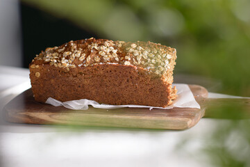Whole Grain rye bread with seeds on a cutting board. Dark background.