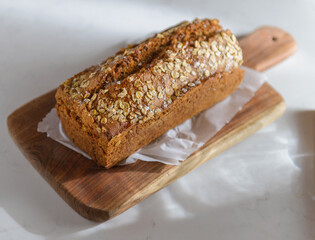 Whole Grain rye bread with seeds on a cutting board. Dark background.