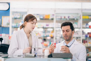Two pharmacists counting drug pills arranging assortment working in drug shelves counter
