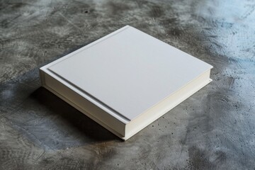 A white book sits on a table, ready to be read