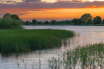 Dreamy light view of reservoir at Marsworth, Buckinghamshire, UK, autumnal colours and blue sunset  evening sky