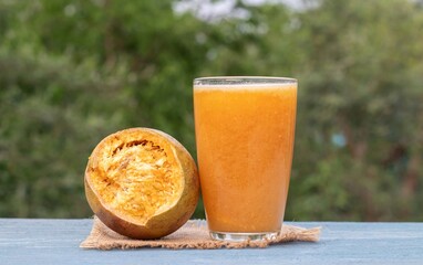 Ripe Indian Bael Fruit Juice or Sarbat in a Glass or Wood Apple Isolated on Wooden Background with Copy Space, Also Known as Aegle Marmelos, Bengal Quince, Japanese Bitter Orange or Stone Apple