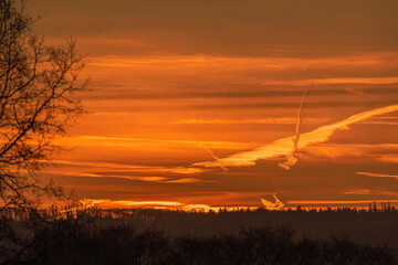 Sunrise sky showing plane contrails firing into the sky, space for text