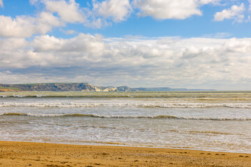 Seascape showing cloudy sky above sea, space for text, winter sunny day, UK England