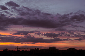 Silhouette of a big city. Dramatic sunset sky. Evening over the metropolis. Outlines of houses. Bright colors of the evening sky. Colorful clouds over Kyiv. Nature of Ukraine. Urban landscape.