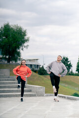in the park a young couple in love doing sports couples warming up healthy lifestyle synchronized...