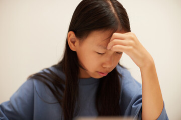 夏休みの小学生の女の子が宿題に悩む様子