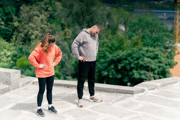 in the park a young couple in love doing sports couples warming up healthy lifestyle synchronized...