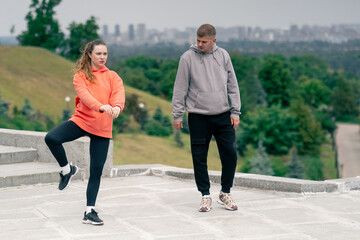 in the park a young couple in love doing sports couples warming up healthy lifestyle synchronized...