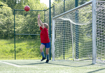 Girl Goalkeeper Tries To Catch Ball In Children'S Football Match