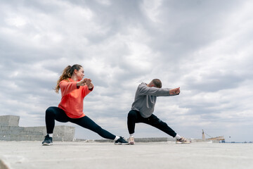 in the park a young couple in love doing sports couples warming up healthy lifestyle synchronized...