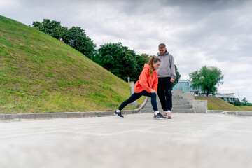 in the park a young couple in love doing sports couples warming up healthy lifestyle synchronized...