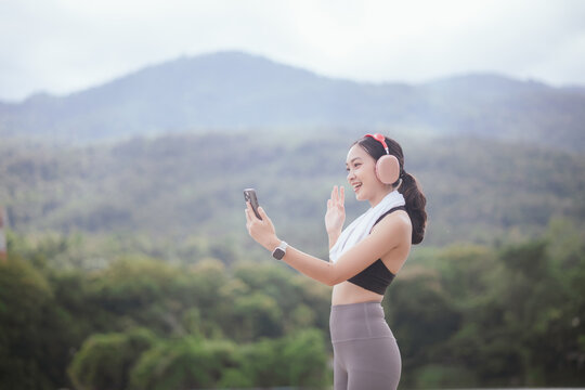 A beautiful woman jogs alone in the city, drinking water. Embracing an active lifestyle, she runs with energy and joy, showcasing fitness, health, and endurance, enjoying the outdoors and nature's bea
