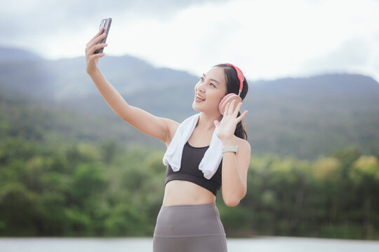 A beautiful woman jogs alone in the city, drinking water. Embracing an active lifestyle, she runs with energy and joy, showcasing fitness, health, and endurance, enjoying the outdoors and nature's bea