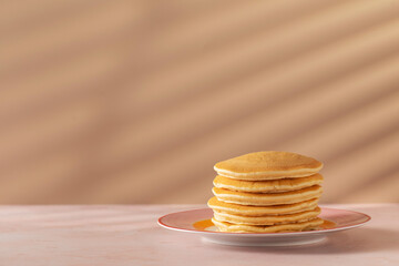 Tasty pancakes stack on plate and copy space on pink