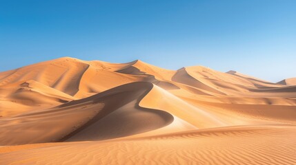 The rolling sand dunes of the Namib Desert in Namibia, with a clear blue sky overhead.