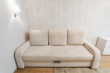 A beige sofa enhances the minimalist living room look, creating a chic, clean, and comfortable space