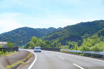 Scenic Drive on a Sunny Day Through Lush Green Mountains