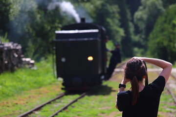 the photographer takes a photo of the locomotive of the Bieszczady Forest Railway