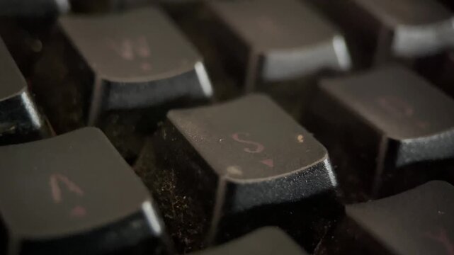 Close-up macro footage of a glowing RGB keyboard. The shot captures the intricate details of the backlit keys, showcasing a vivid array of colors and dynamic lighting effects