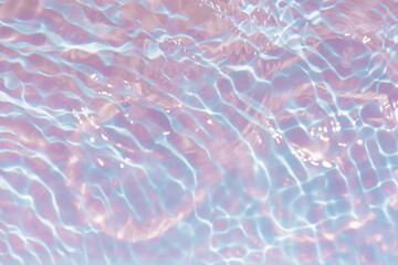 Blue water with ripples on the surface. Defocus blurred transparent blue colored clear calm water surface texture with splashes and bubbles. Water waves with shining pattern texture background.
