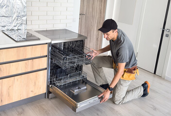Worker repair dishwasher at home.
