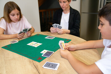 Fototapeta premium A family is playing a card game on a table