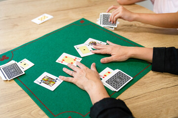 Two people playing a card game on a green table