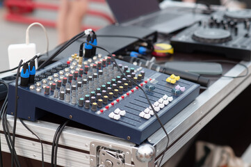 Sound music mixer control panel. Small DJ console on a portable mobile aluminum table. Street festival concept and organization of people's leisure. Selective focus