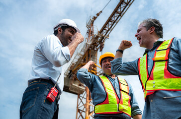 Group of workers at construction site are discussing construction progress with a tower crane in...